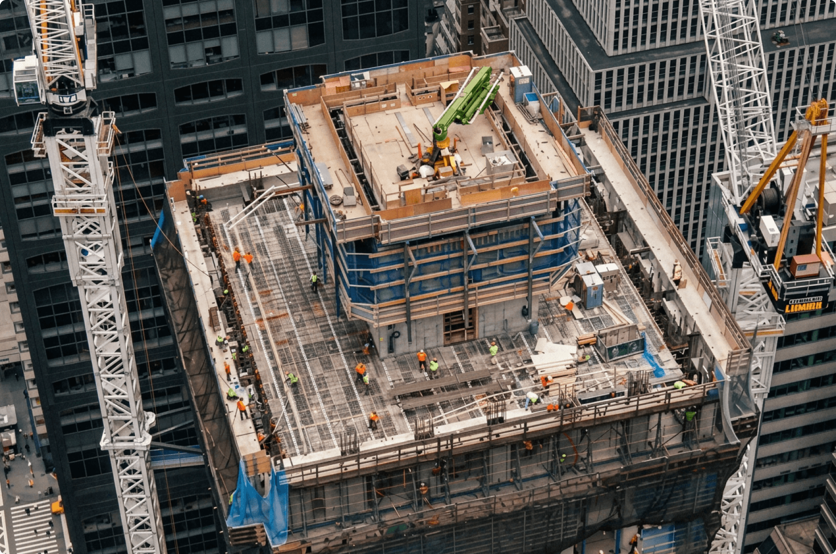 An aerial view of an active high-rise concrete pour, the operation the conversations run.